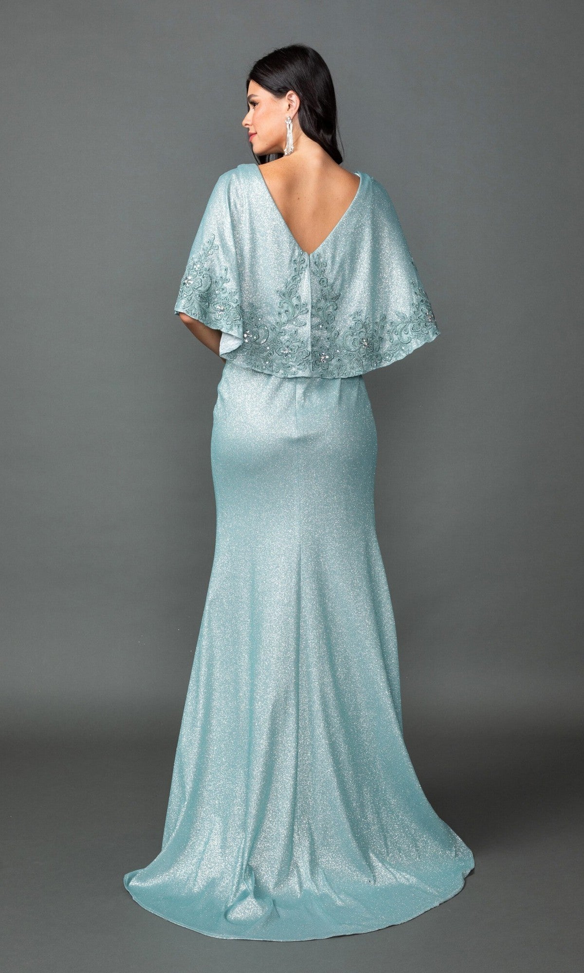 A woman is seen from behind, standing against a gray backdrop and wearing the Dancing Queen 4569 long formal dress—a shimmering light blue gown featuring a ruched fitted bodice and elegant capelet detail.